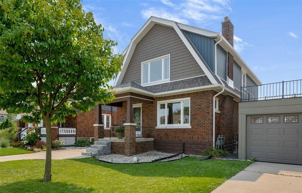 Two-storey brick and shingle house at 2371 Lincoln Road, Windsor, with a covered front porch, attached garage and a young tree on the front lawn.