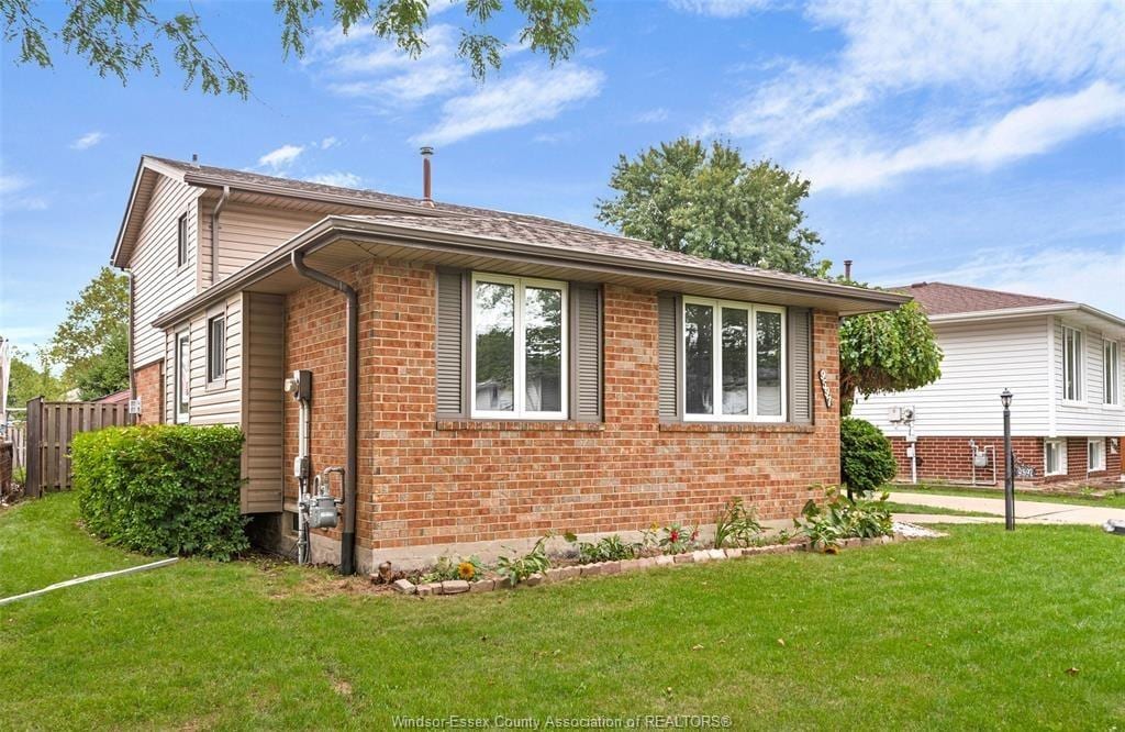 Brick back-split home at 9597 Avery Lane with a front lawn